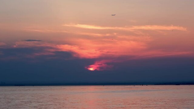 Sea, boat and plane in sunset view