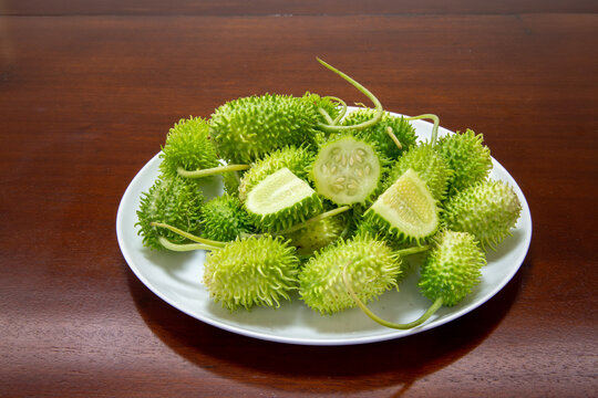 Gherkin, maxixe (Cucumis anguria), green fruits, whole and in cut, with its typical external filaments.