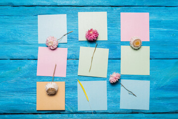 Blank empty paper pages with copy space and dried flowers on the blue flat lay background. Plan. To do list.