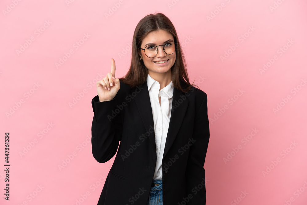 Wall mural young business caucasian woman isolated on pink background showing and lifting a finger in sign of t