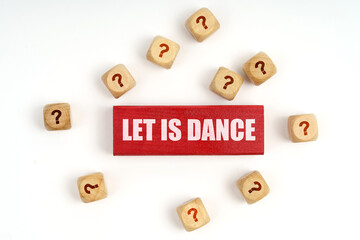 On the table are cubes with questions and a red plaque with the inscription - Let Is Dance