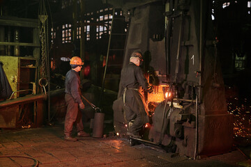 Fototapeta na wymiar Worker controlling metal melting in furnaces