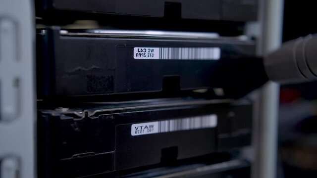 Cleaning hard disk drives rack from dust with an anti-static brush.