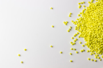 Yellow granules of polypropylene or polyamide on a white background. Plastics and polymers industry. Copy space