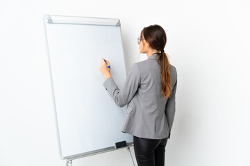 Young Ireland woman isolated on white background giving a presentation on white board and writing...