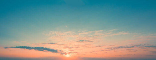 Panoramic picture of dawn sky with sun above the horizon surrounded by little cloudiness. Light Clouds at dawn. Orange Stripe of sky on blue horizon with rising sun, template for replacing sky.