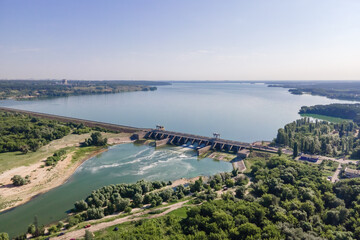 Fototapeta na wymiar Hydroelectric dam with flowing green water through gate, aerial view from drone