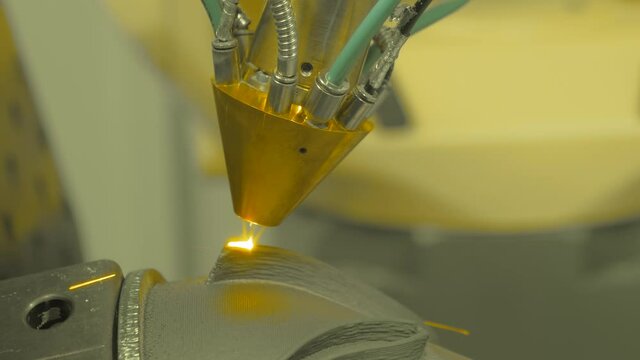 Direct metal deposition - advanced additive laser melting and powder spray manufacturing technology for repair, rebuild metal workpieces - close up. Metalworking, robotic, industrial concept