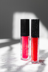 Lip gloss and sun shadow . The concept of lip gloss without labels. Decorative cosmetics. Lip care....