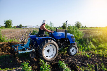 The farmer works in the field with a tractor. Agroindustry and agribusiness. Field work...