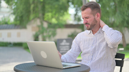 Fototapeta premium Mature Adult Man with Laptop having Neck Pain 