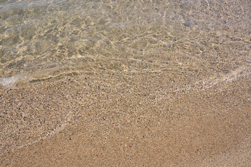Clear waves on tropical sandy beach in Crete Greece.