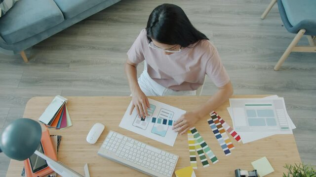 Slow motion of creative smartphone app designer developing mobile interface choosing colors working alone in apartment. People and freelance work concept.