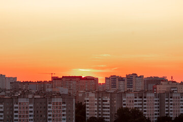 Horizontal cityscape photography of a city skyline with multi-storey buildings in residential area at light orange dusk