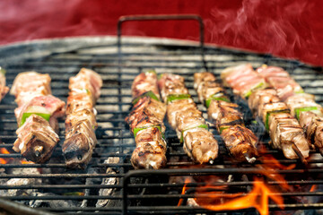 chicken skewers with green and red pepper on the Grill with glowing flames and glowing coals. Outdoor dining concept.
