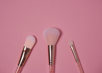 Makeup brushes on pink background flatley
