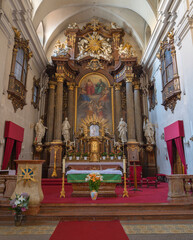 Fototapeta na wymiar VIENNA, AUSTIRA - JUNI 17, 2021: The prebytery and main altar of baroque church Alserkirche with the Holy Trinity painting by Joseph Ritter von Hempel (1826).