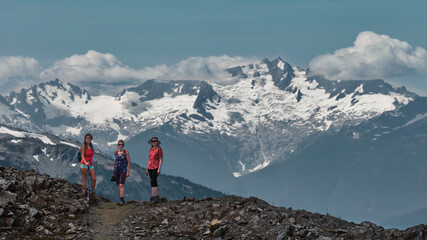 Fototapeta premium Group of people on cliff with glacier view. Whistler Blackcomb Ski resort in summer. British Columbia. Canada
