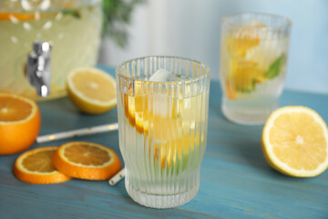 Delicious refreshing lemonade with orange slices on light blue wooden table