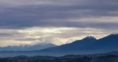 Nuvole grigie sopra le montagne innevate