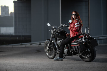Naklejka na ściany i meble Girl biker sexually posing on motorcycle at night city