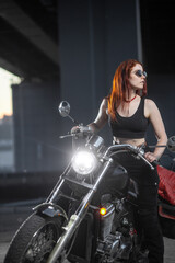 Naklejka na ściany i meble Girl biker sexually posing on motorcycle at night city