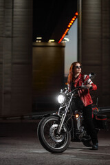 Obraz na płótnie Canvas Girl biker sexually posing on motorcycle at night city