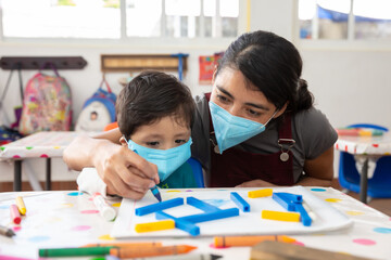 Fototapeta premium Mexican teacher and child with masks at school after covid-19 quarantine