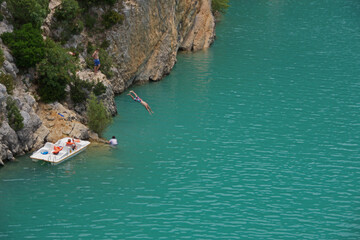 Obraz premium Jugendliche üben ihre Fertigkeiten beim Springen von Felsen in das tiefe türkise Wasser im Gorges du Verdon (Frankreich)