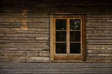 Obraz na płótnie Canvas Old wooden log house window frame exterior with glass
