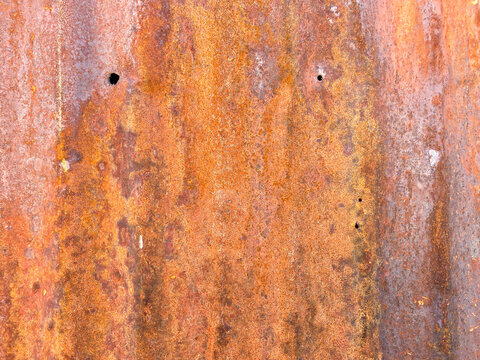 close up view of rusted rusty old steel wall door panel with gunshot bullet holes damage