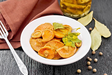 Mushrooms salted in plate on dark board