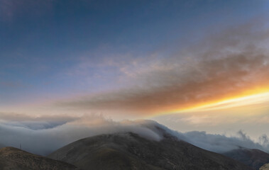 Fototapeta premium Beautiful mountains landscape, huge fluffy clouds descended to the mountain tops. Nature mountain wallpaper.