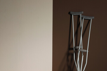 Naklejka premium Pair of axillary crutches on color background. Space for text