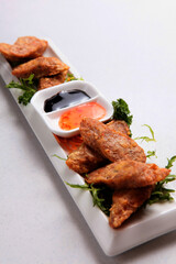 deep fried wu xiang pork meat roll with sauces in white background fusion asian halal menu