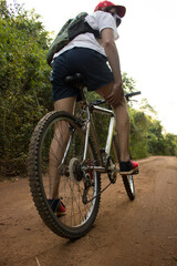 Fototapeta na wymiar Hombre montando una bicicleta de montaña en un sendero verde, haciendo deporte en la selva