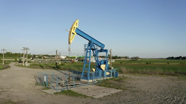 Crane boom shot moving down oil pumpjack working near Ploiesti, Romania