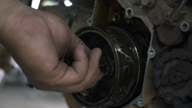 Mechanic removing magnetic wheels unscrew the nut on motorcycle engine mechanic, the motorbike in the shop, automatic motorbike repair