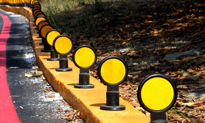 Road reflector beside a curved road,Traffic reflector,Road reflector 