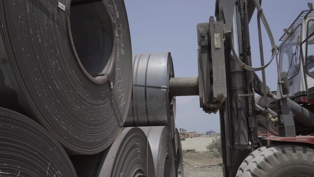 Tonnes of rolled steel are stacked in bulk terminal shipping yard