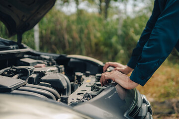 Serious man front of car breakdown and open bonnet on roadside. Car broken concept.