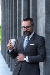 Handsome businessman drink coffee outdoor in morning on street