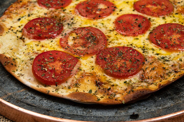 Neapolitan Brazilian pizza with mozzarella cheese and tomato slices with oregano
