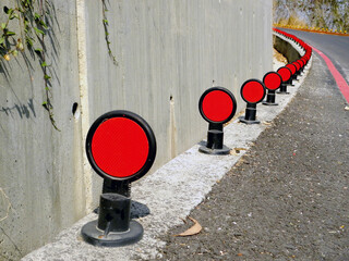 Road reflector beside a curved road,Traffic reflector,Road reflector 
