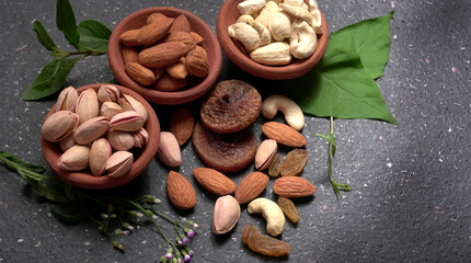 Pistachios or Pista nuts decorated with green leaves. plain background, top view.Flat lay.