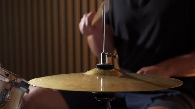 Slow-motion drummer plays sticks on a drum kit, setting the rhythm