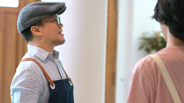 4K Asian male coffee shop manager briefing man and woman staff team before working. Small business cafe and restaurant owner instruct part time employee preparing service to customers before opening