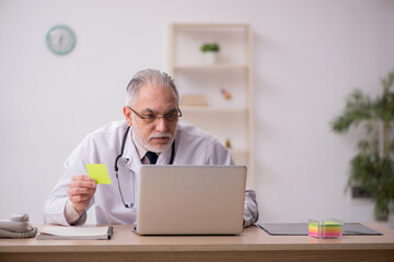 Old male doctor working in the clinic