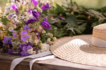 Fototapeta na wymiar A straw hat next to a bouquet of wild flowers. Poster
