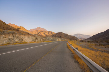 Mountain empty road view with dried grass. Roads of Fujarah - UAE